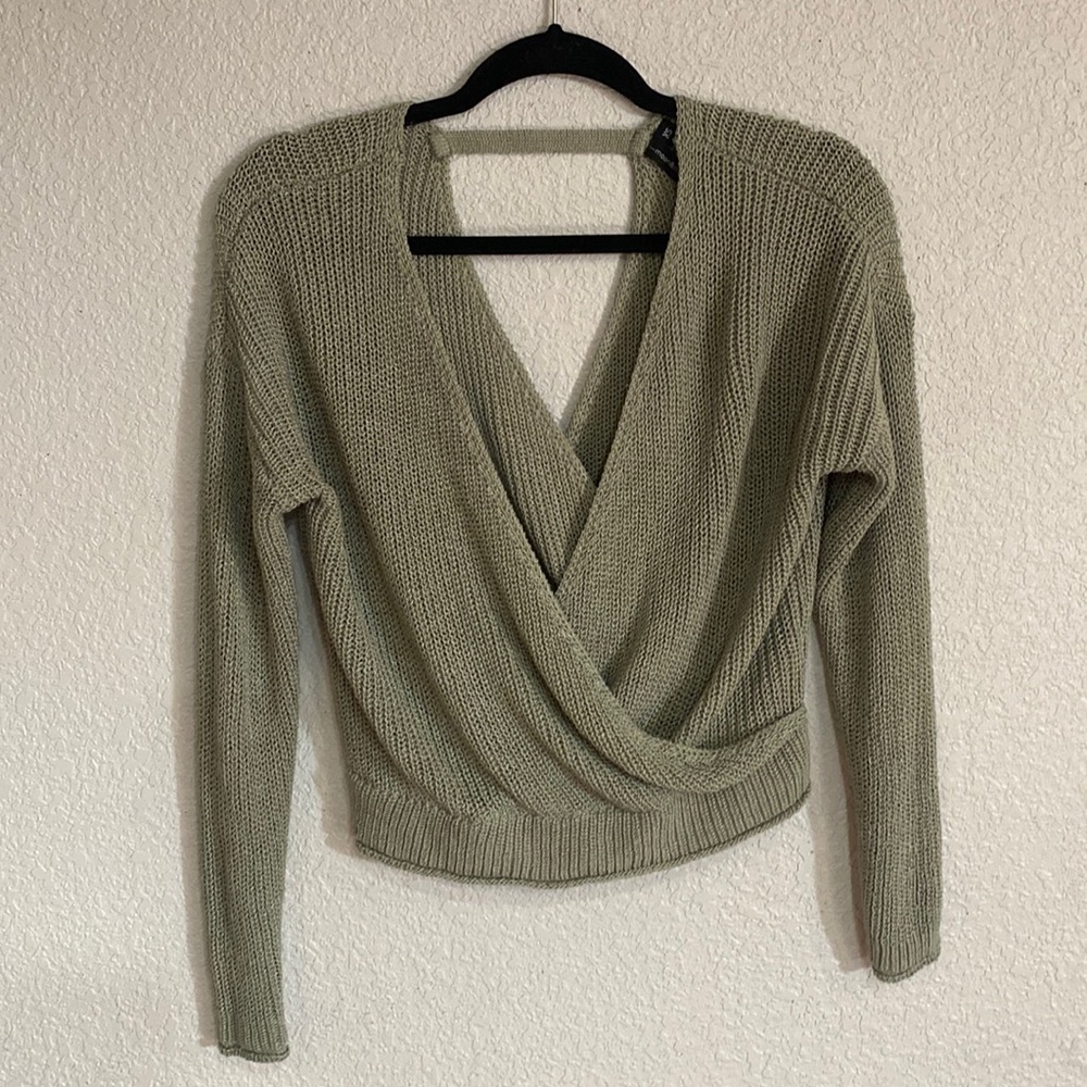 Green sweater, fun back, and fitting waist.